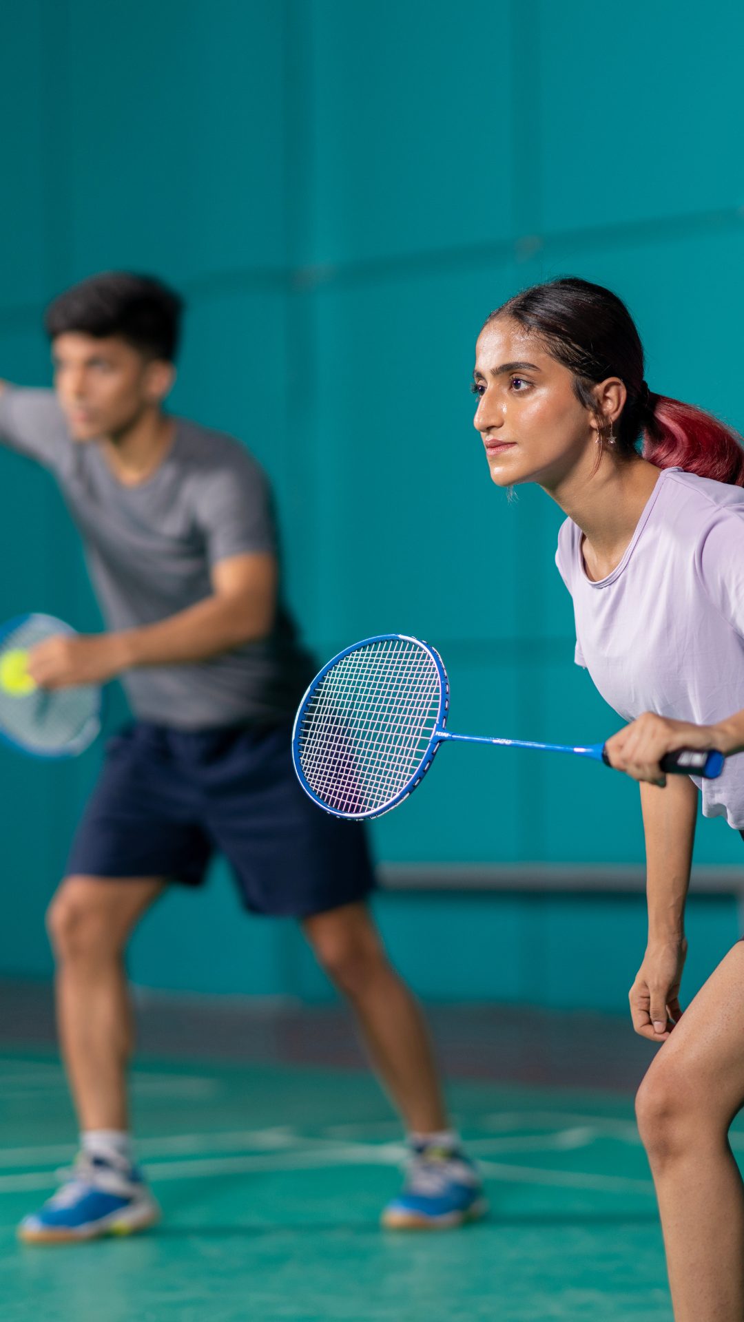 Two players ready at the net in a badminton hall