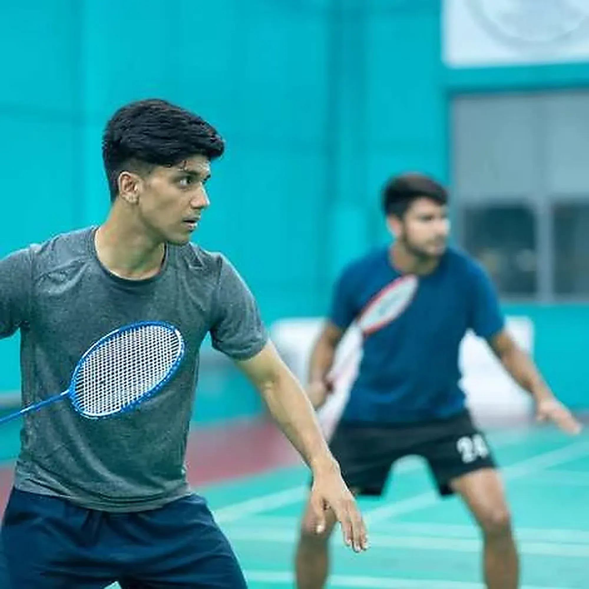 Two doubles partners ready at the back of the court