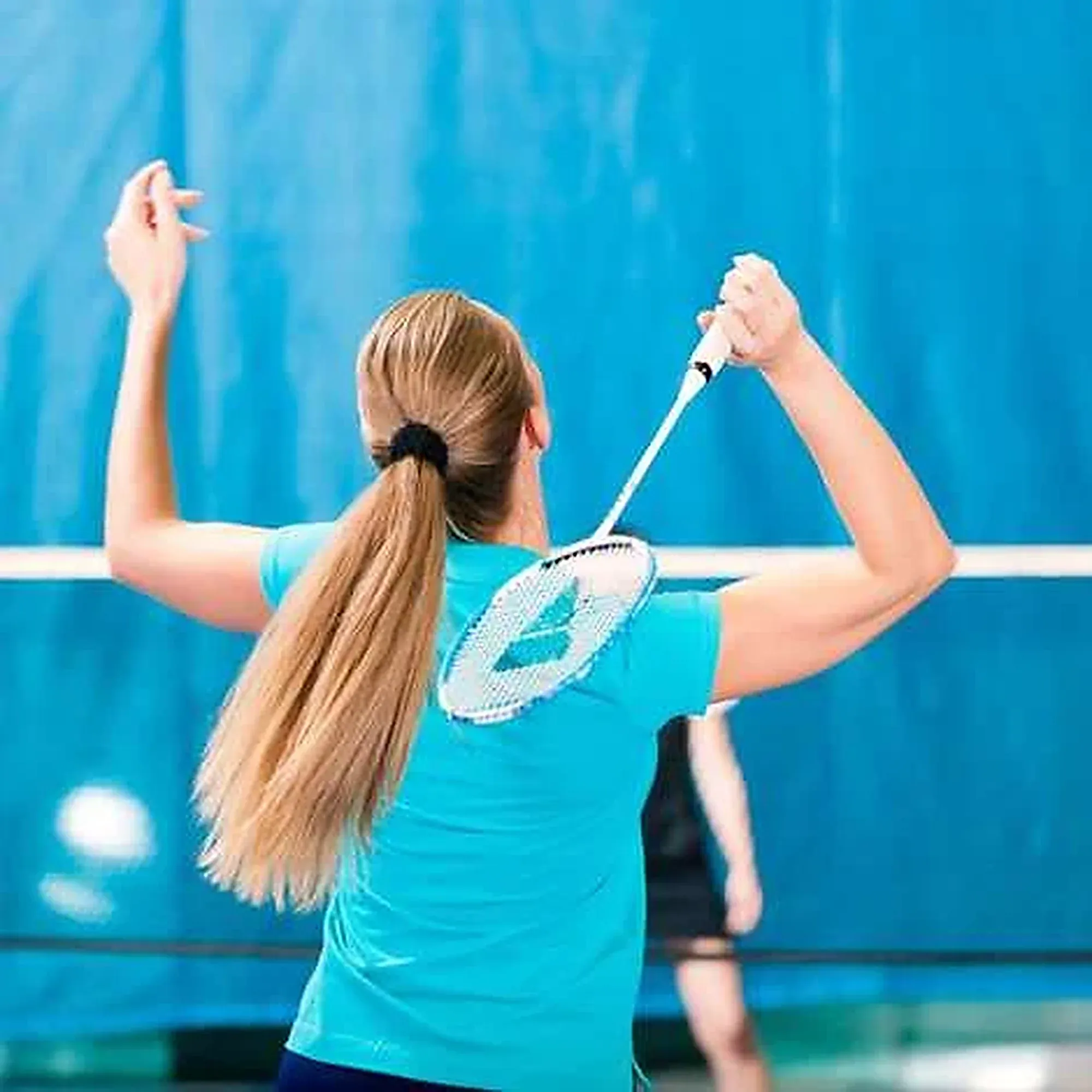 A player reaches up for an overhead shot