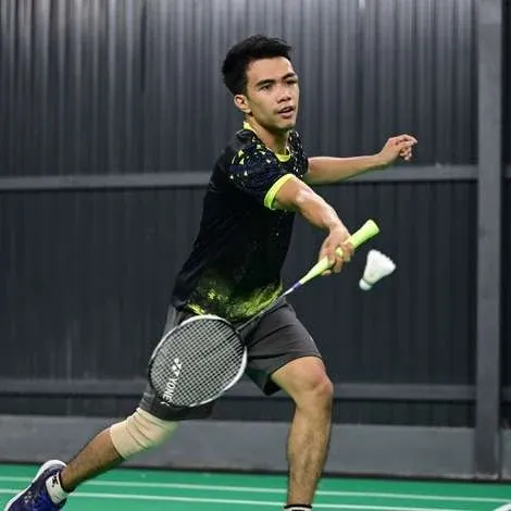 A player plays a forehand on a dark court