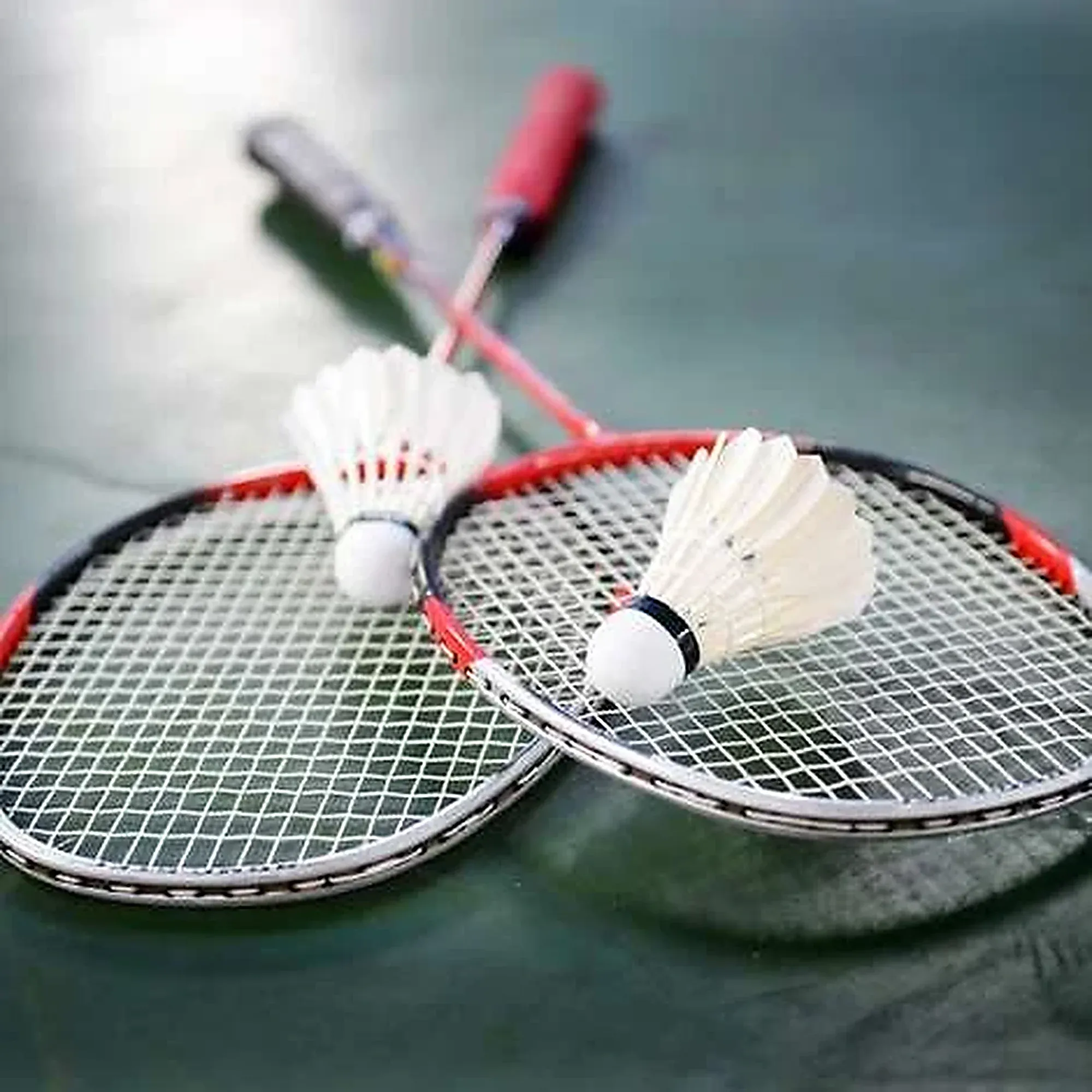 Two rackets and shuttles lying on a court